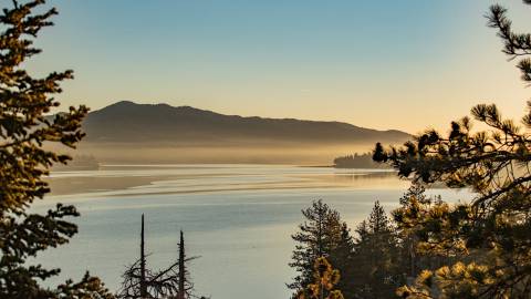 A photo taken during a golden hour in Big Bear Lake, the fog and lake water gently reflecting the gold-ish light.