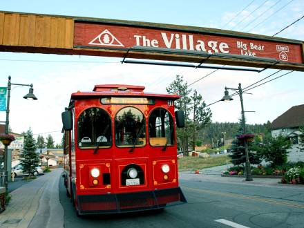 The Mountain Trolley driving underneath Big Bear's "The Village Sign"