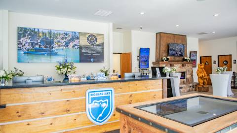 The Big Bear Visitor Center lobby with a front desk and interactive table map in the foreground.