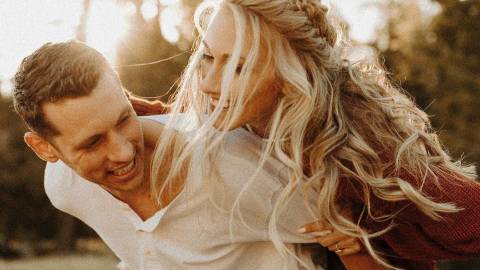 A man carries his fiancé on his back during a playful engagement shoot in Big Bear Lake, CA.