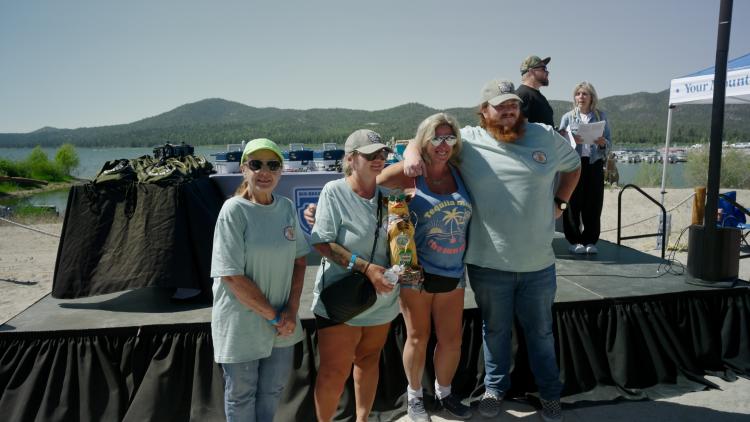 A photo of the 1st, 2nd, and 3rd place 2025 FF50K female winners, the first place winner is holding the bear like trophy
